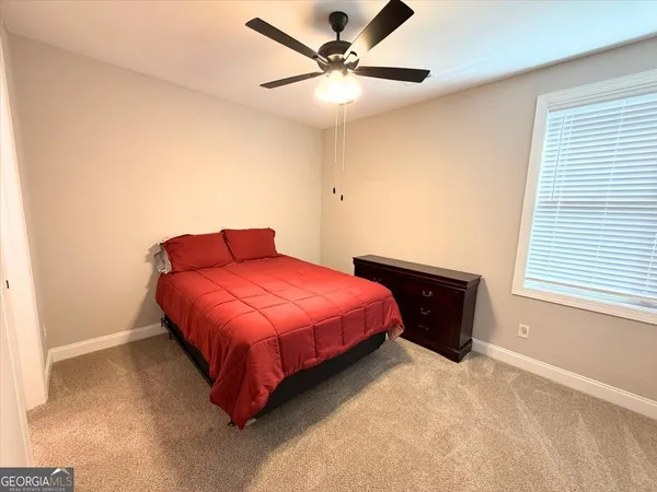 a spacious bedroom with a bed and a window