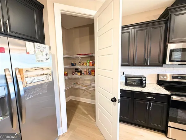 a kitchen with stainless steel appliances granite countertop a refrigerator and a stove