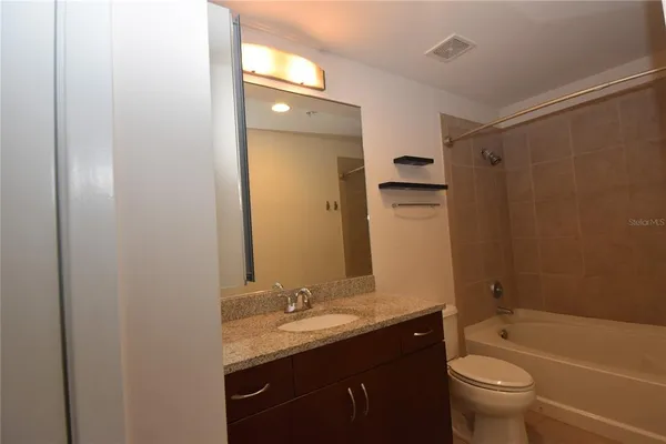 a bathroom with a granite countertop sink toilet and shower