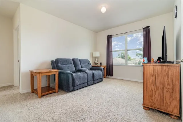 a living room with furniture a flat tv screen and a window