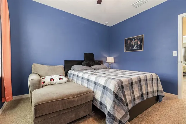 a bedroom with a bed and painting on the wall