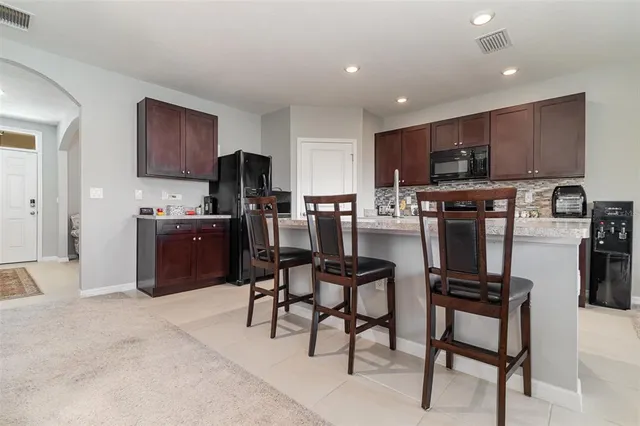 a view of kitchen with cabinets stainless steel appliances dining table and chairs