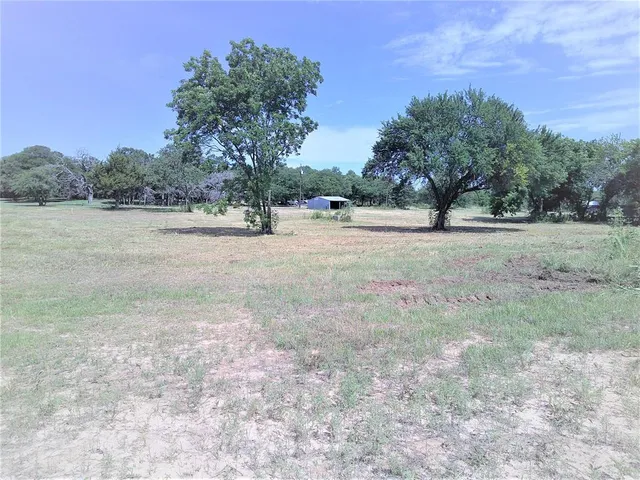 a view of dirt yard with a trees