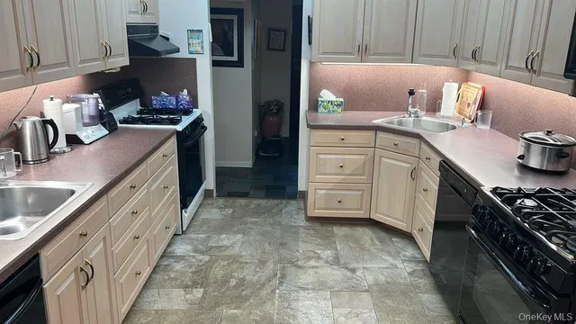a kitchen with granite countertop a sink stove and cabinets