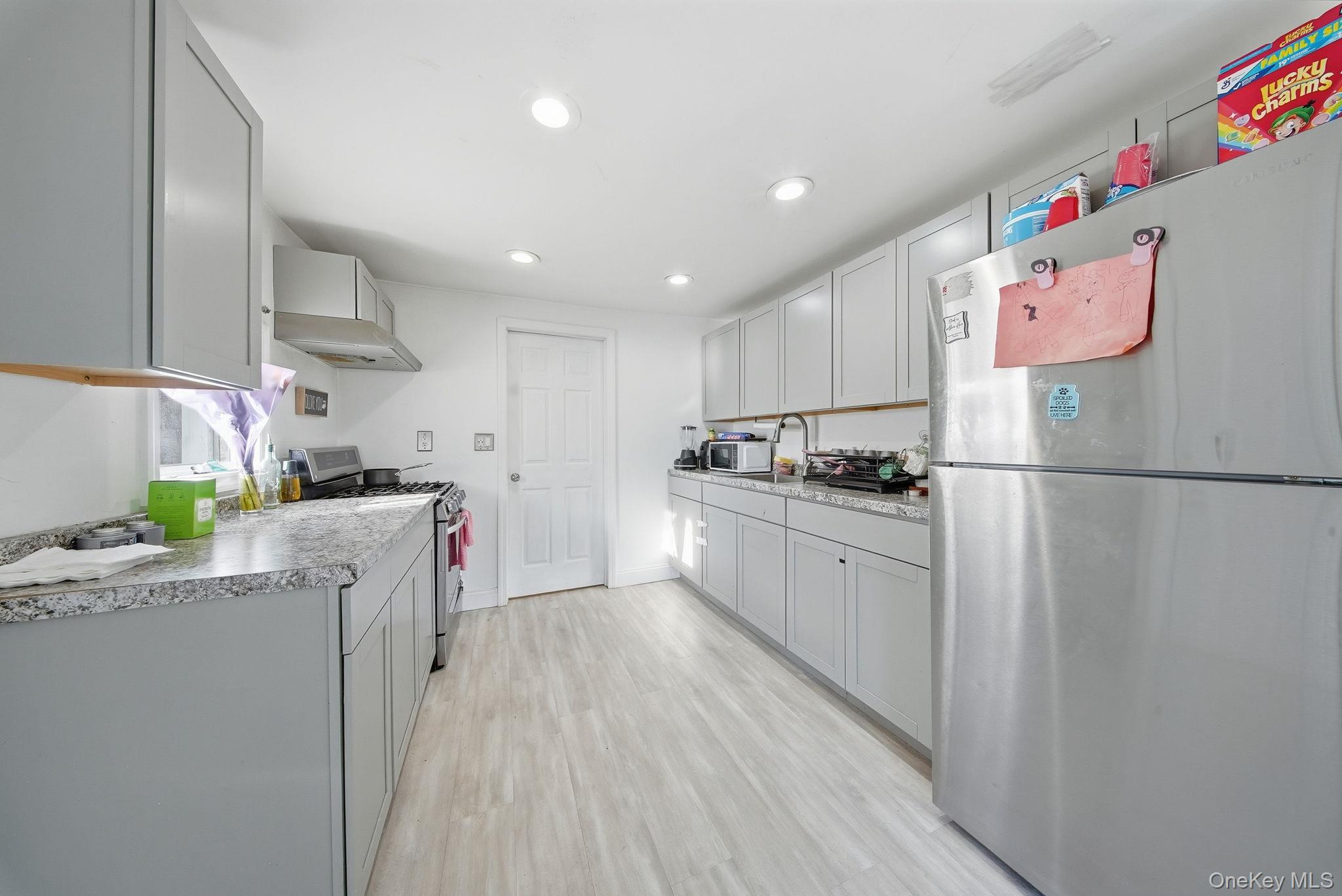 4 Old Road Cuddebackville, NY 12729 - Photo 8 of 16 a kitchen with granite countertop a refrigerator a sink dishwasher and white cabinets with wooden floor