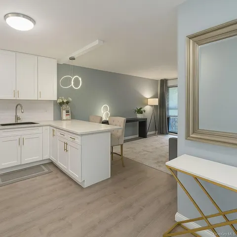 a kitchen with a sink cabinets and wooden floor
