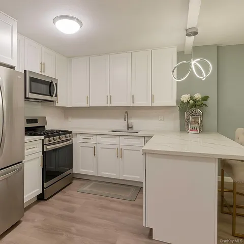 a kitchen with cabinets appliances a sink and a counter top space