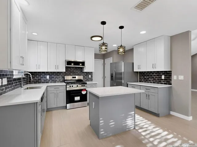 a kitchen with kitchen island granite countertop a stove oven and a sink