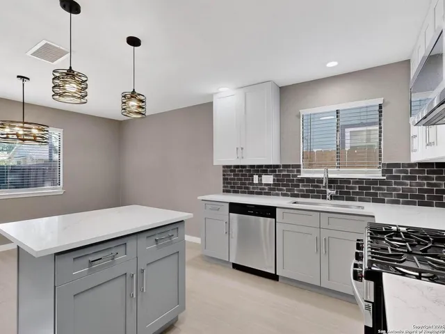 a kitchen with stainless steel appliances a sink stove and cabinets