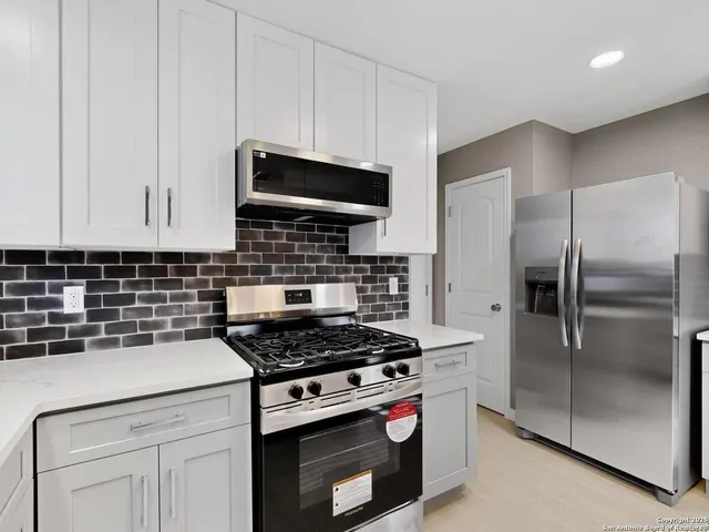 a kitchen with cabinets and stainless steel appliances