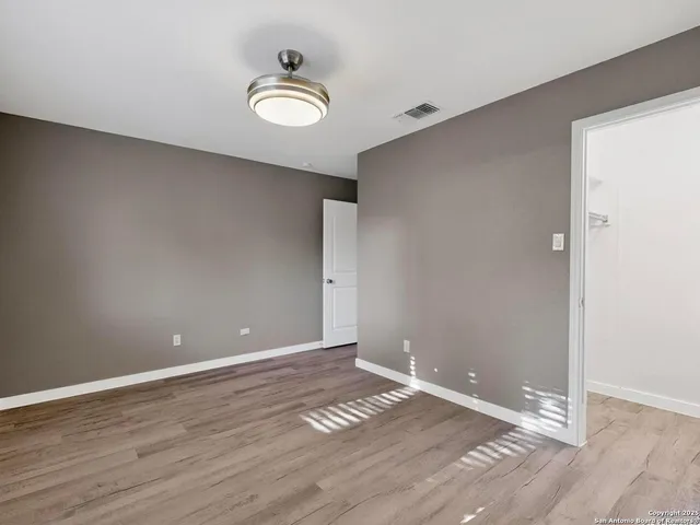 a view of an empty room with wooden floor