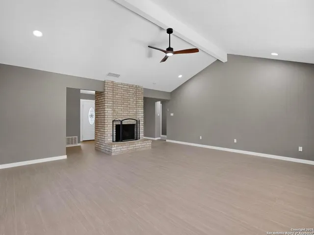 an empty room with fireplace and windows