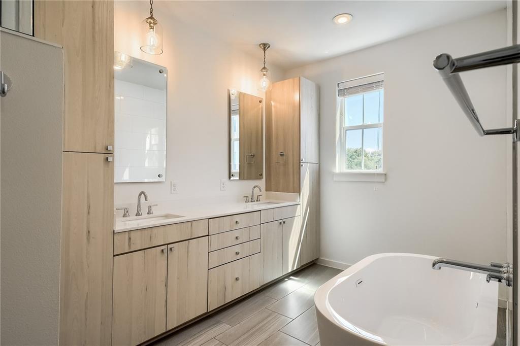 2624 Metcalfe Road, Unit 7 Austin, TX 78741 - Photo 13 of 31 a bathroom with a double vanity sink and mirror with bathtub