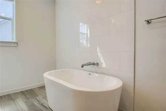 a bathroom with a double vanity sink and mirror with bathtub