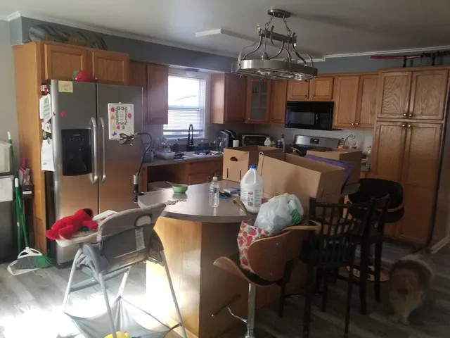 a living room with furniture a flat screen tv and kitchen view