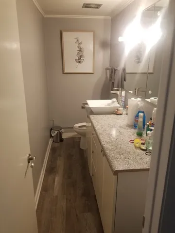 a bathroom with a granite countertop sink a toilet and mirror