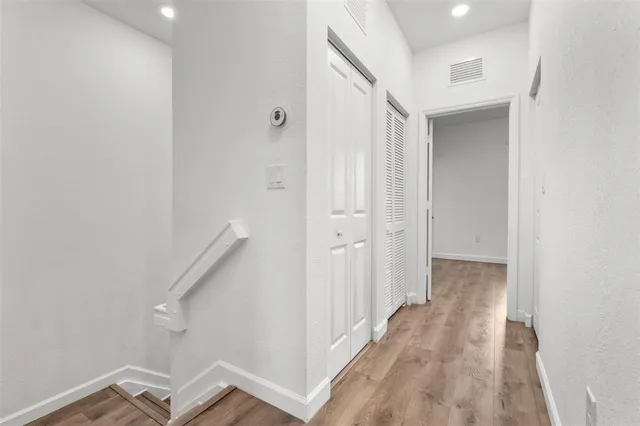 a view of a hallway with wooden floor