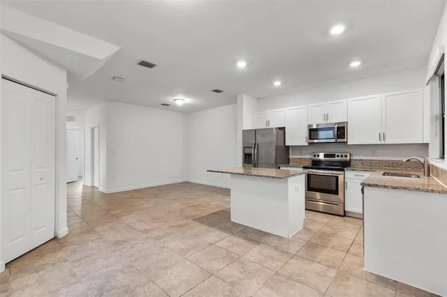 a kitchen with stainless steel appliances granite countertop a refrigerator and a stove top oven