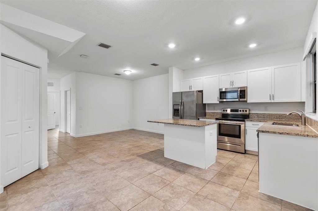 340 Northeast 208th Terrace, Unit 340 Miami, FL 33179 - Photo 17 of 38 a kitchen with stainless steel appliances granite countertop a refrigerator stove top oven and sink