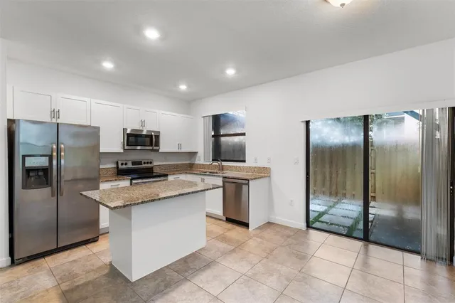 a kitchen with stainless steel appliances granite countertop a refrigerator and a sink