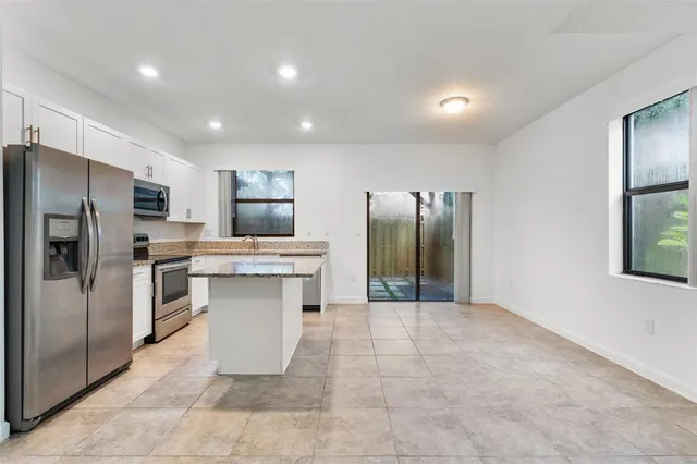 a kitchen with granite countertop a sink and a stove top oven