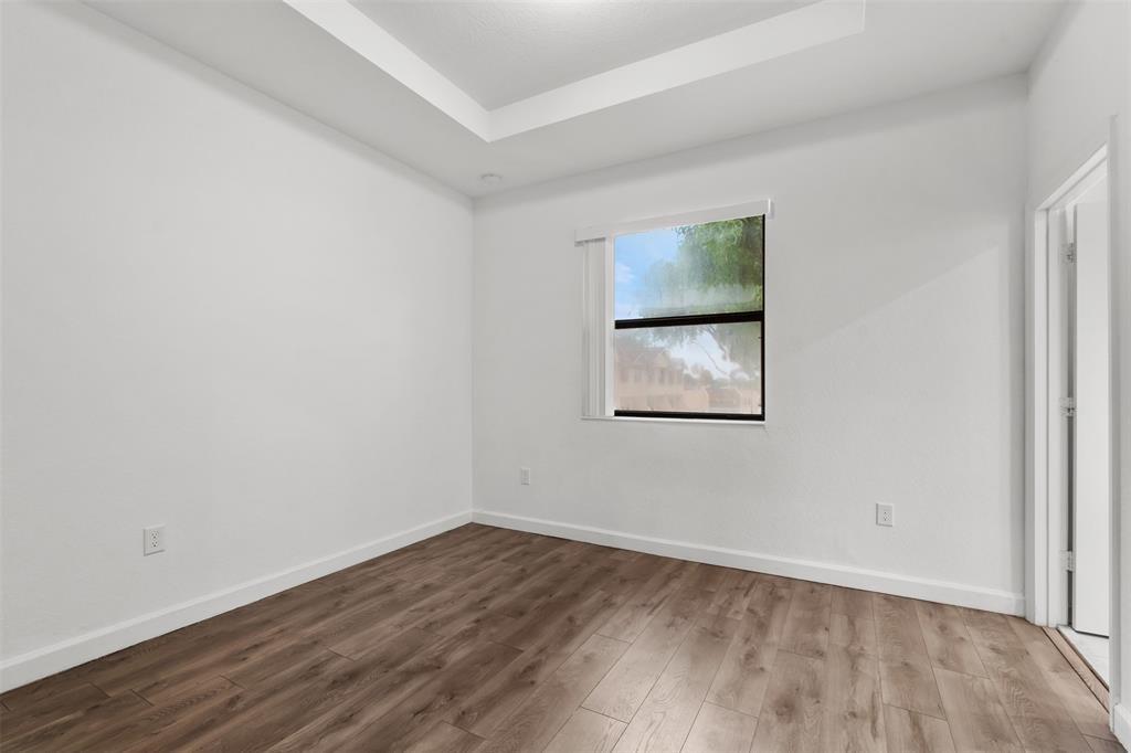 340 Northeast 208th Terrace, Unit 340 Miami, FL 33179 - Photo 8 of 38 a view of an empty room with wooden floor and a window