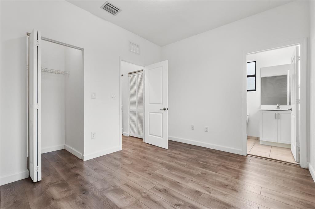 340 Northeast 208th Terrace, Unit 340 Miami, FL 33179 - Photo 10 of 38 a view of an empty room with wooden floor and a bathroom
