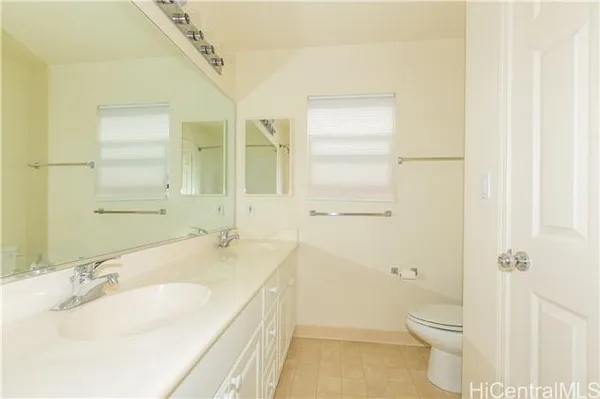 a bathroom with a granite countertop sink a toilet and a mirror