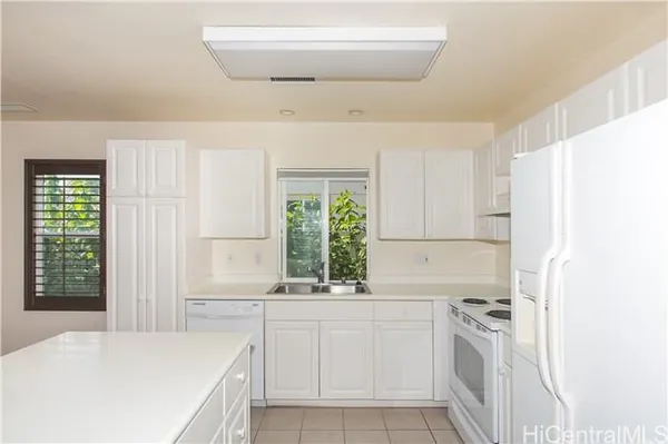 a kitchen with white cabinets and white appliances