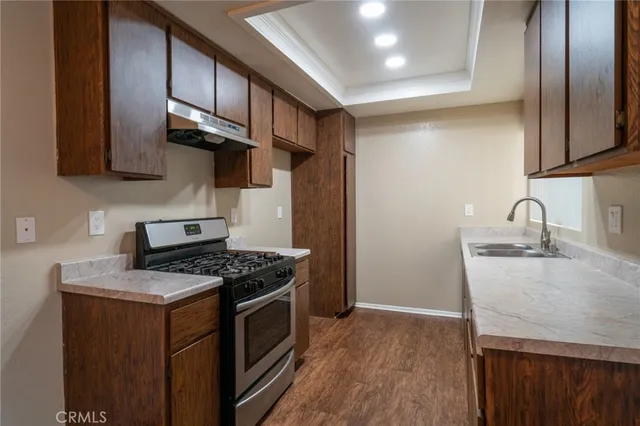 a kitchen with stainless steel appliances granite countertop a sink stove and refrigerator