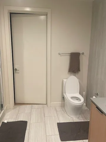 a white toilet sitting next to a shower