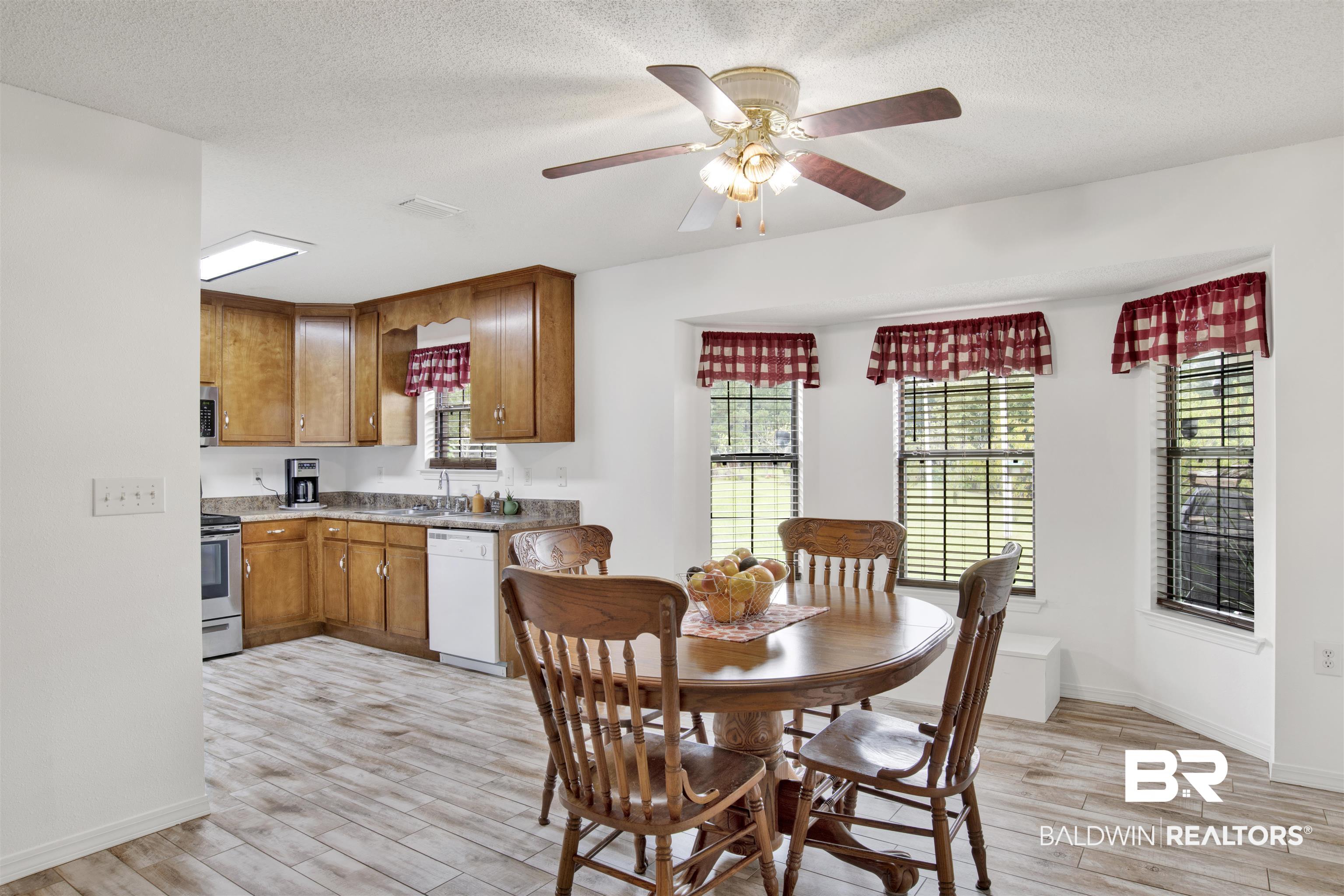 54563 Splinter Hill Road Perdido, AL 36562 - Photo 14 of 29 Dining room featuring a healthy amount of sunlight, ceiling fan, and light hardwood / wood-style floors