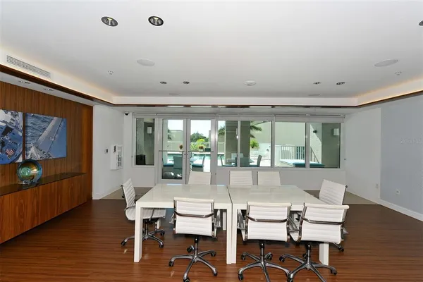 a living room with couch floor to ceiling windows and wooden floor