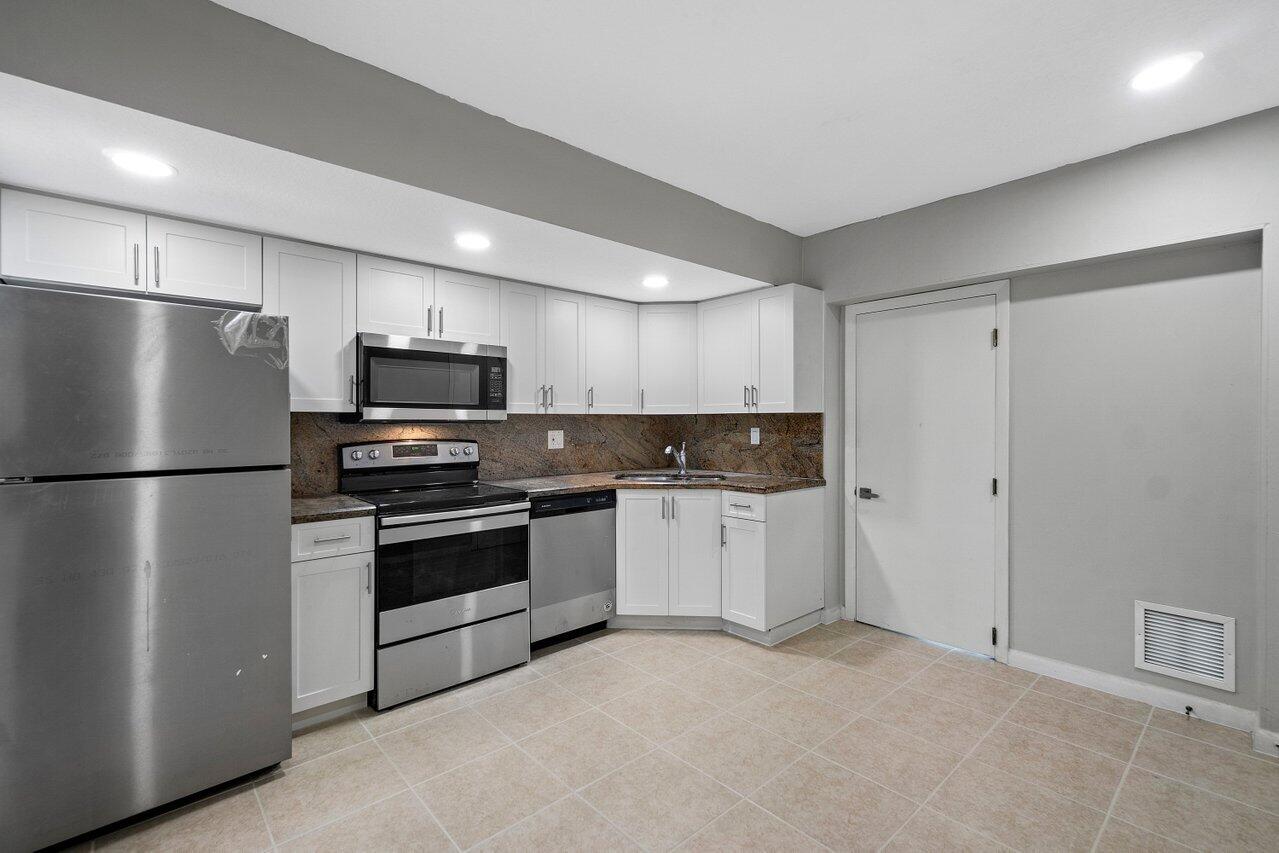 209 Southwest 6th Street, Unit 209 Boca Raton, FL 33432 - Photo 13 of 37 a kitchen with stainless steel appliances a refrigerator sink and microwave