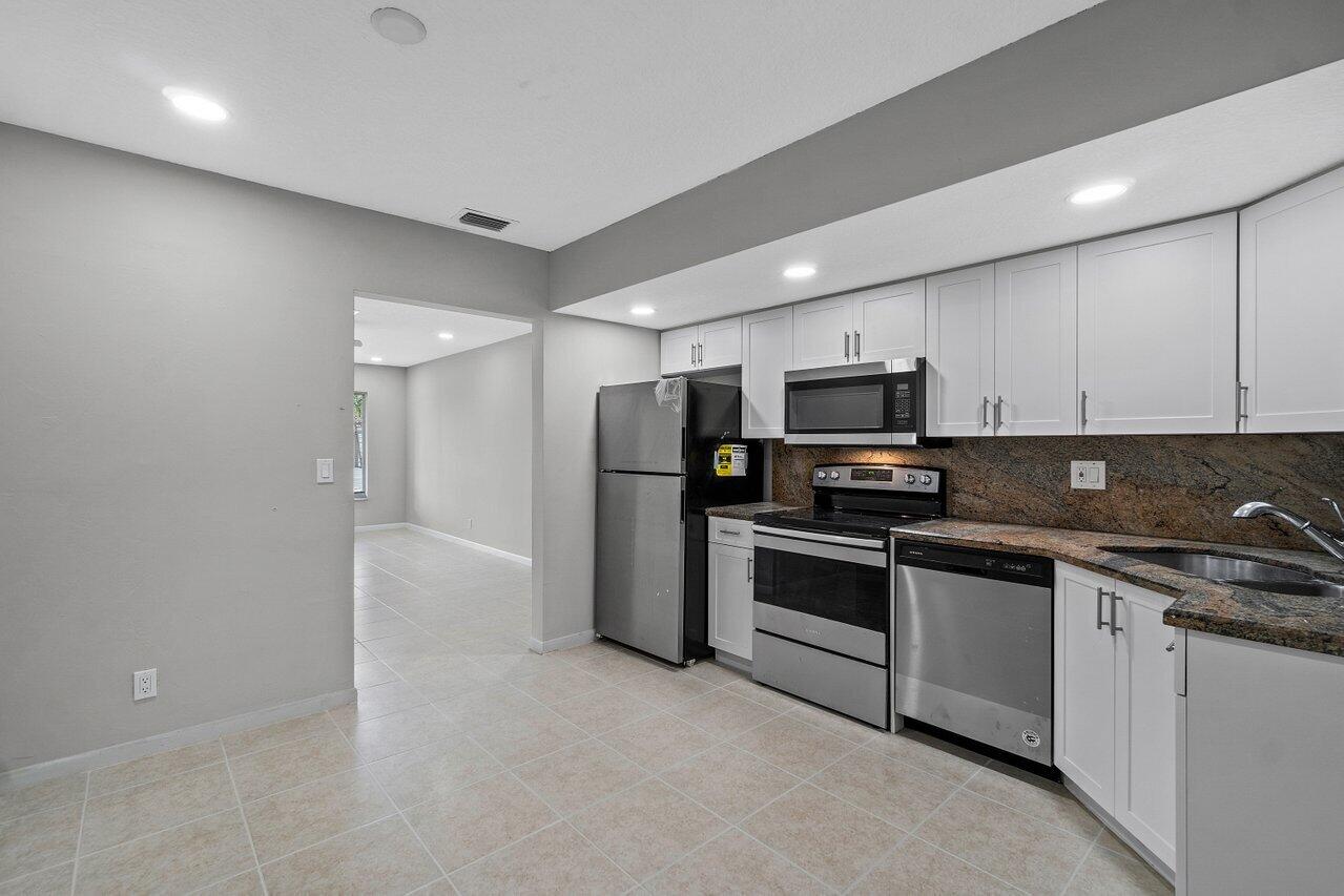 209 Southwest 6th Street, Unit 209 Boca Raton, FL 33432 - Photo 15 of 37 a kitchen with stainless steel appliances granite countertop a stove and a sink