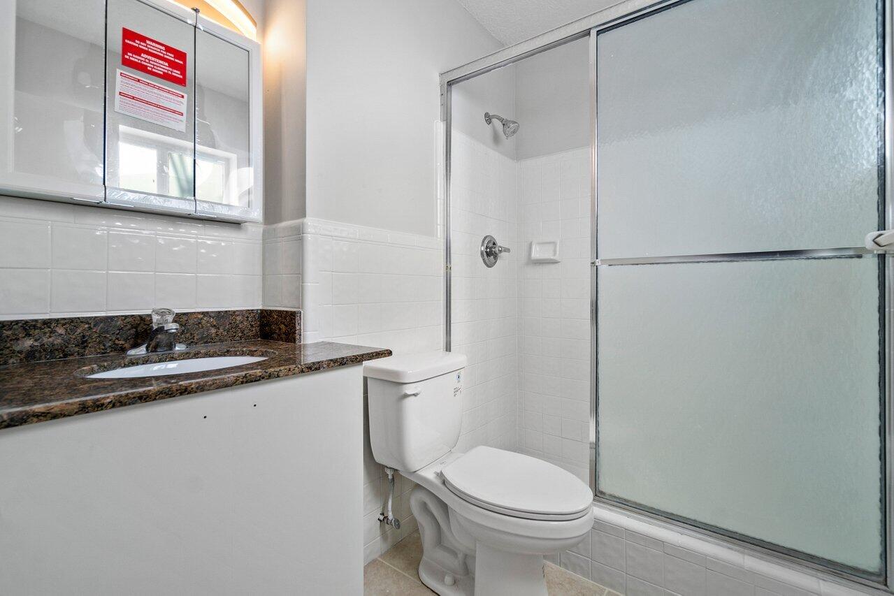 209 Southwest 6th Street, Unit 209 Boca Raton, FL 33432 - Photo 19 of 37 a bathroom with a sink a toilet and shower