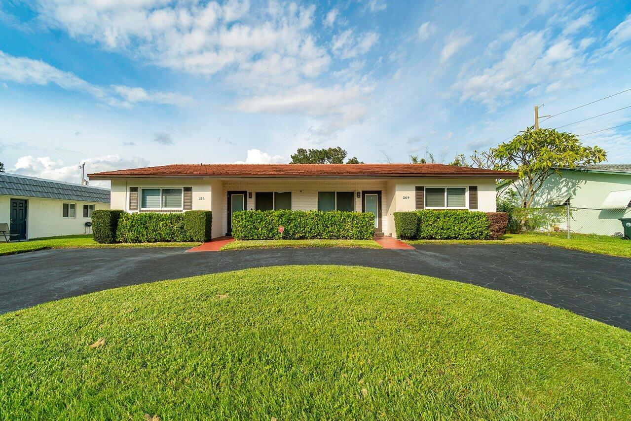 209 Southwest 6th Street, Unit 209 Boca Raton, FL 33432 - Photo 2 of 37 a front view of a house with a yard