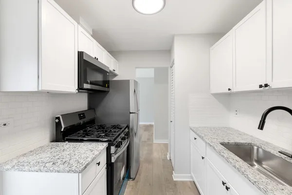 a kitchen with stainless steel appliances granite countertop a sink stove and microwave