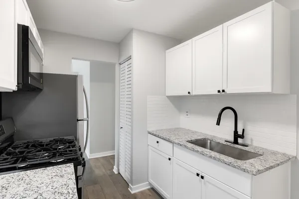 a kitchen with stainless steel appliances granite countertop a sink stove and cabinets