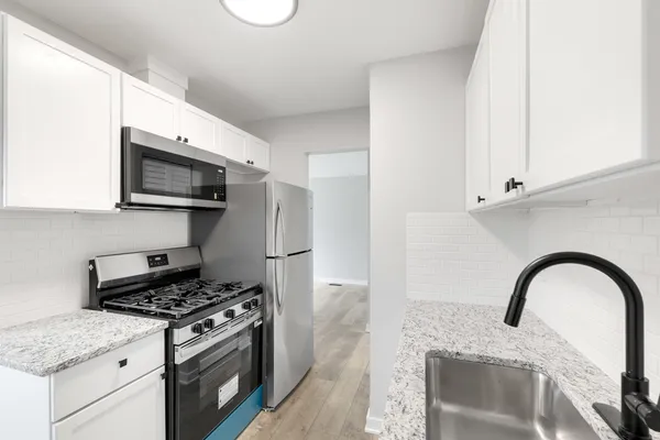 a kitchen with stainless steel appliances kitchen island a stove a sink and a microwave