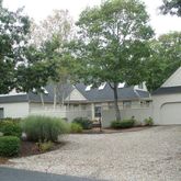 a view of a house with a yard and large tree