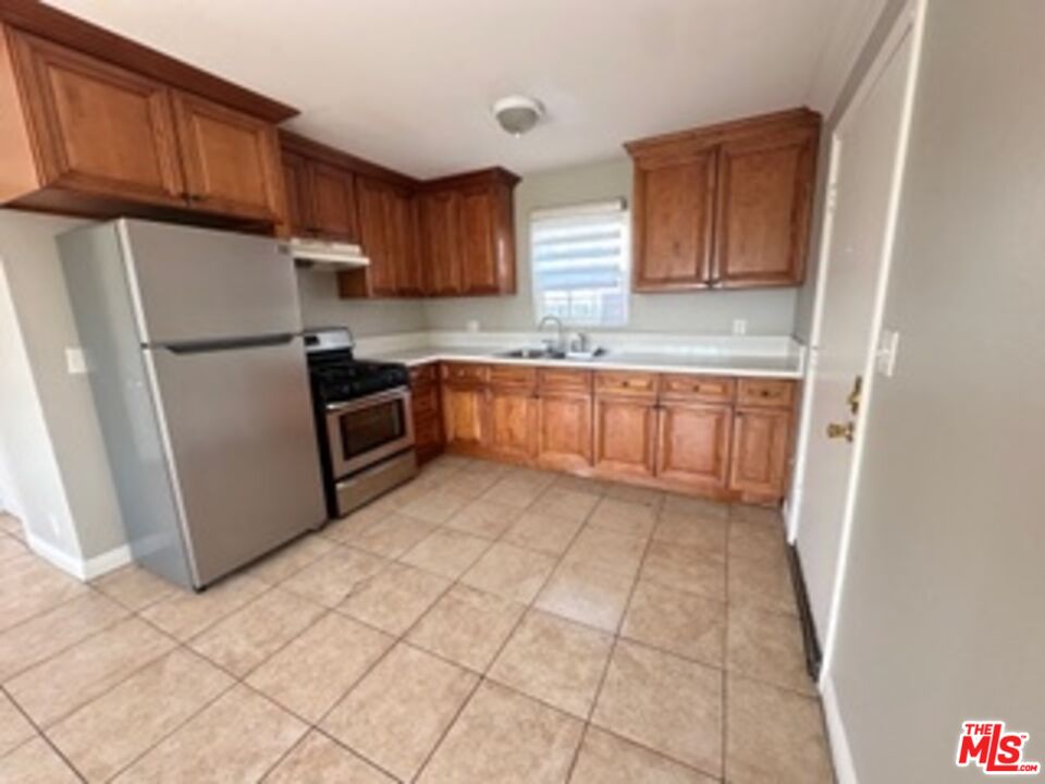 6137 Toltec Way, Unit 7 Los Angeles, CA 90042 - Photo 2 of 8 a kitchen with granite countertop a refrigerator sink and cabinets