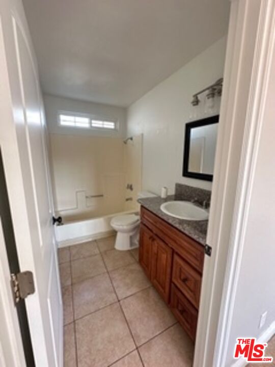 6137 Toltec Way, Unit 7 Los Angeles, CA 90042 - Photo 4 of 8 a bathroom with a granite countertop sink mirror vanity and toilet