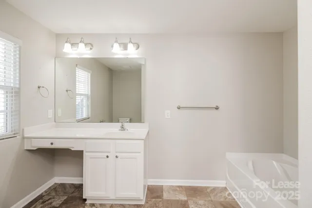 a bathroom with a sink tub and a mirror
