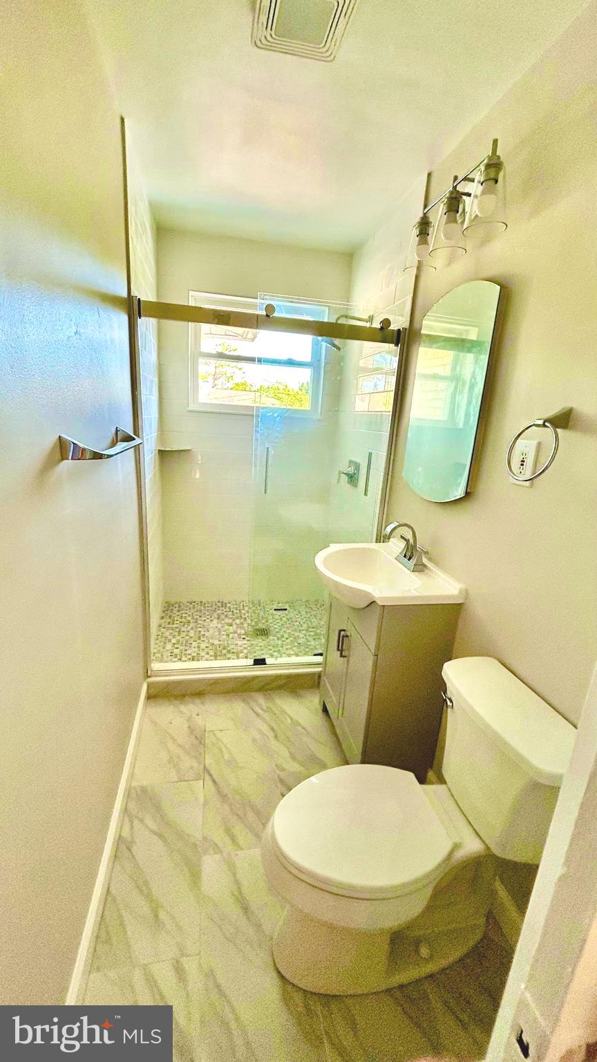 5319 Pooks Hill Road, Unit 1 Bethesda, MD 20814 - Photo 25 of 37 a white toilet sitting next to a bathroom sink and a mirror