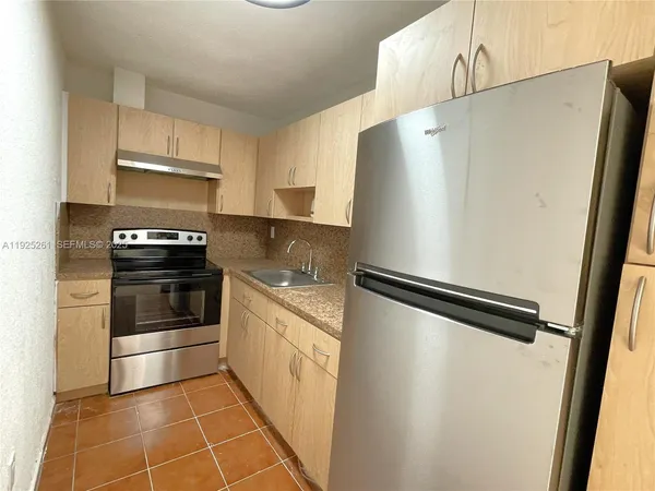 a kitchen with granite countertop a refrigerator and a stove