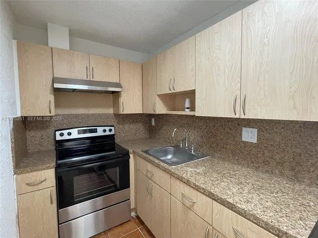 a kitchen with granite countertop a stove and a sink