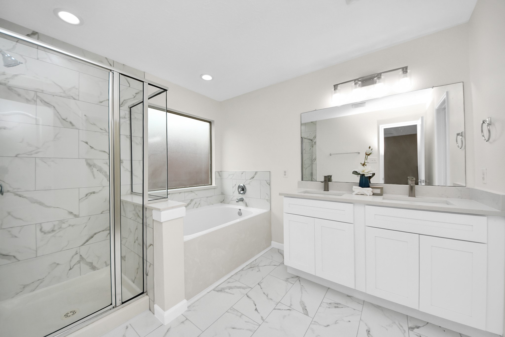 a spacious bathroom with a bathtub sink and mirror