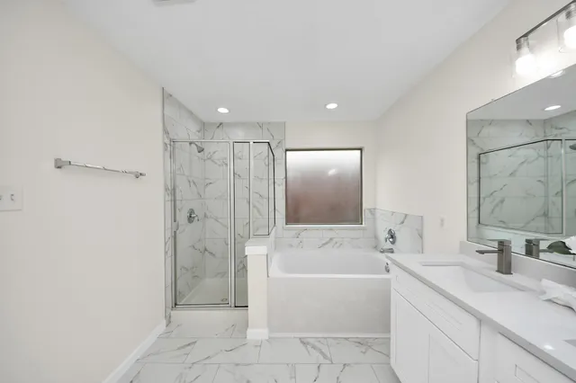 a bathroom with a tub sink shower and mirror