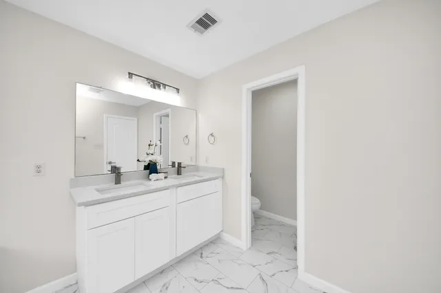 a bathroom with a sink a toilet and a mirror